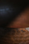 A brass singing bowl without traditional coating, leaving the metal piece with naked surface, natural burn marks and unique reddish due to burning reaction.