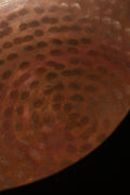 A brass singing bowl without traditional coating, leaving the metal piece with naked surface, natural burn marks and unique reddish due to burning reaction.