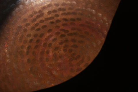 A brass singing bowl without traditional coating, leaving the metal piece with naked surface, natural burn marks and unique reddish due to burning reaction.